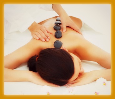 Beautiful woman receiving hotstone massage at spa and wellness center